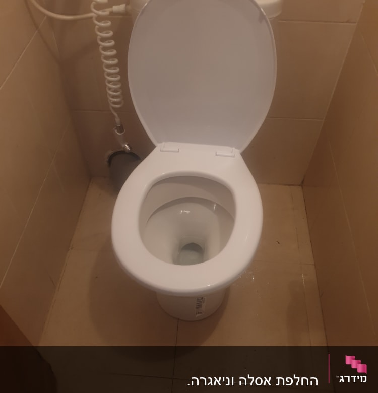 אסלה פתוחה עם צינור מים גמיש ליד